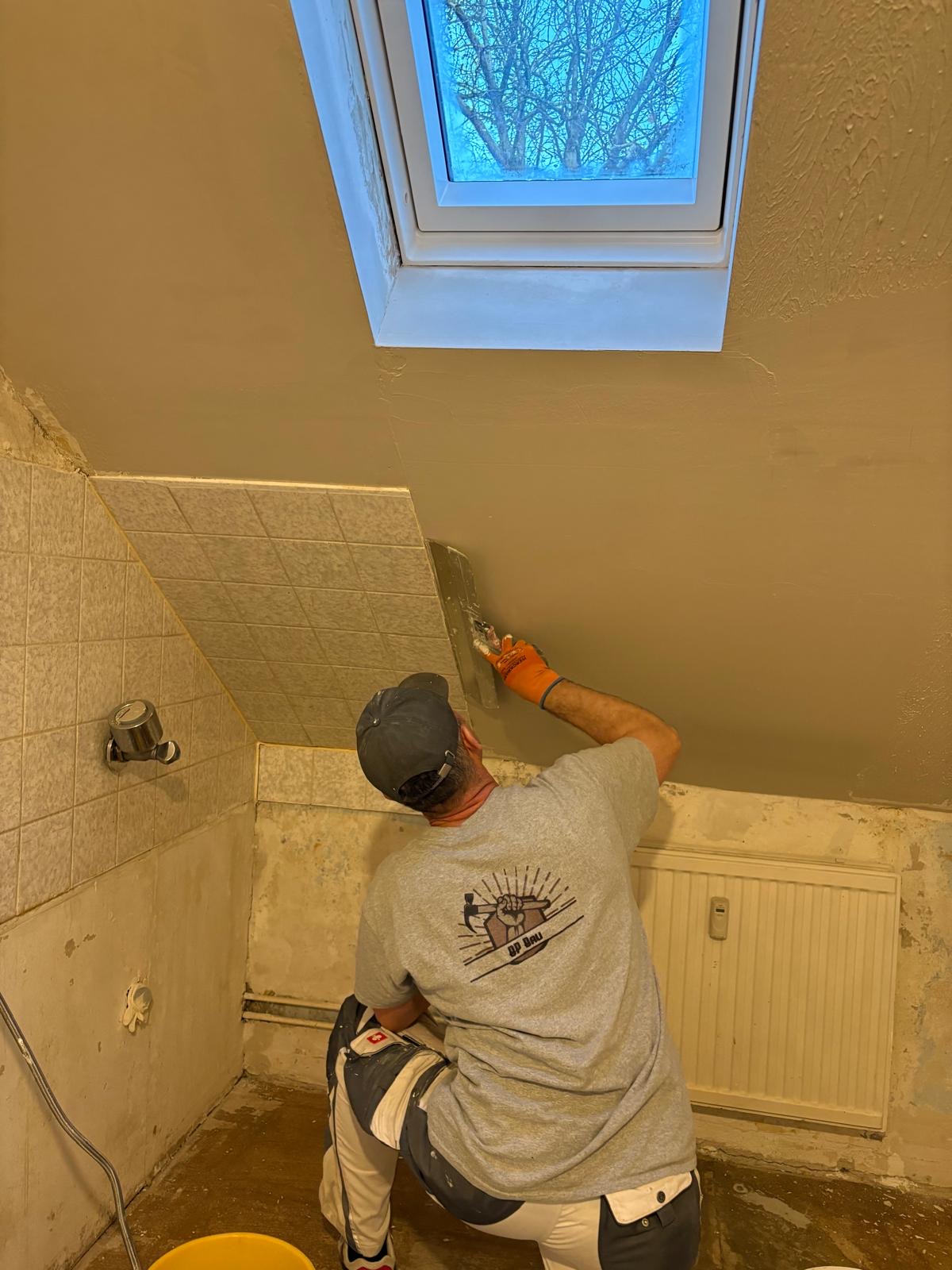 Handwerker von BP Garten & Bau beim Verspachteln einer Dachschräge